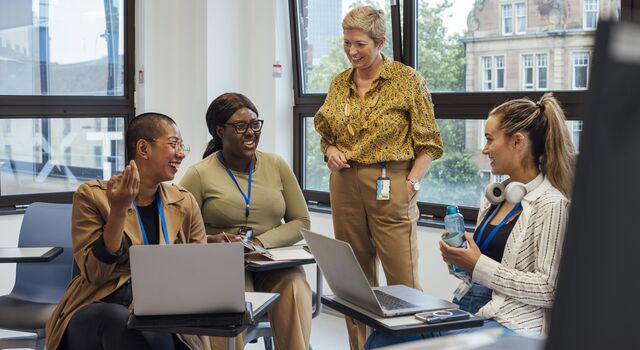 COLOUR-IMAGE_female-teacher-discussing-with-three-students_apr26