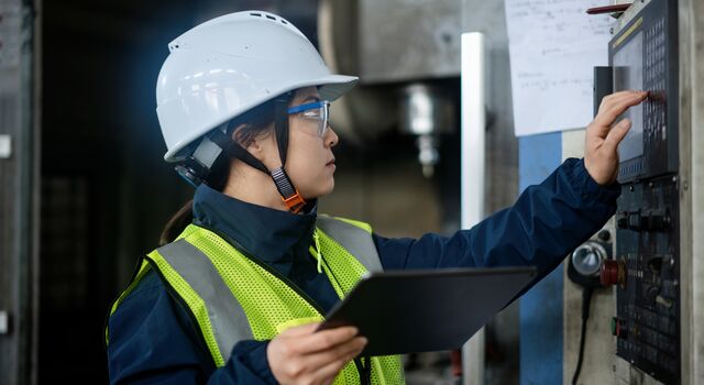 COLOUR-IMAGE_woman-pressing-buttons-on-keypad-in-factory_apr26