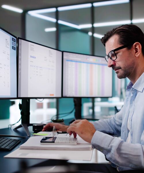 COLOUR-IMAGE_man-in-office-working-monitors_feb26